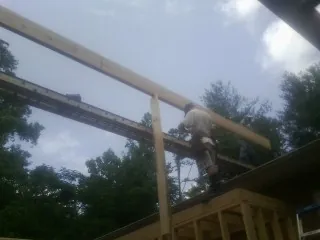 Carpenter setting a ridge beam over a new addition frame — Ice Dam Removal by Roofing Brothers in Beaumont