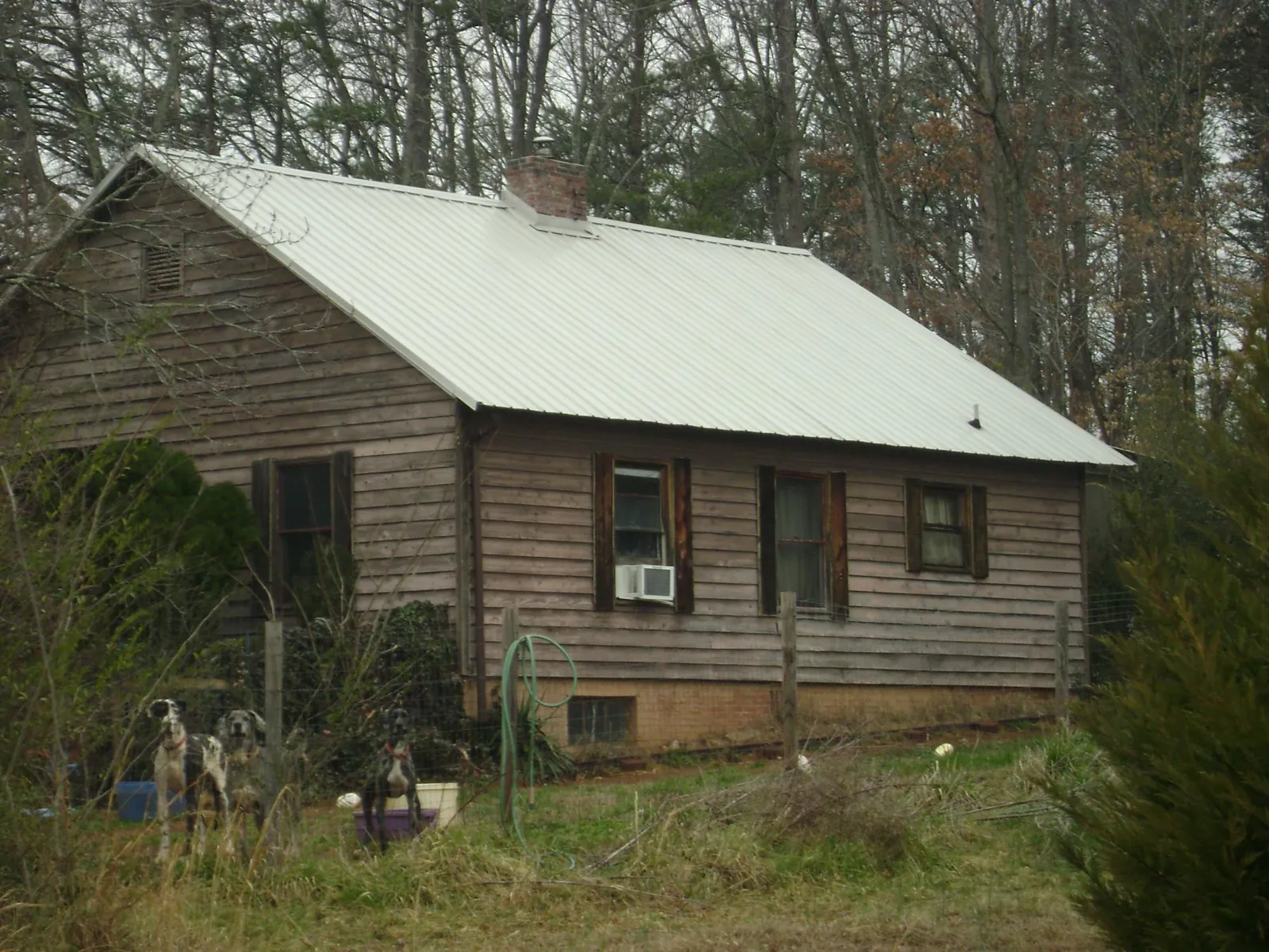 White metal roof on an old wood sided farmhouse, from a Metal Roof Installation job in Beaumont